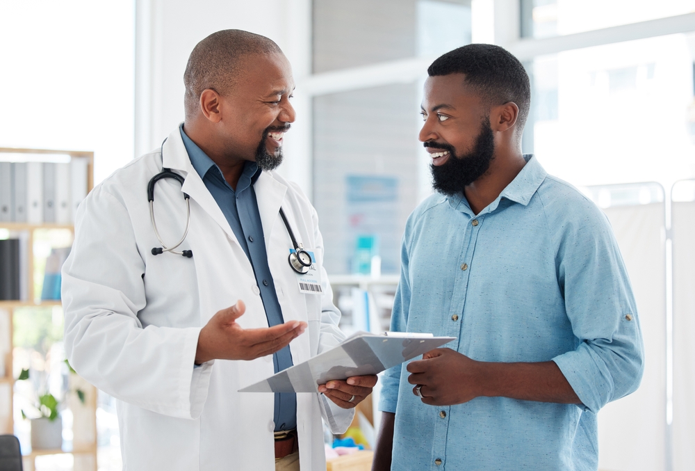 Doctor,,Black,Man,And,Patient,With,Clipboard,In,Consultation,,Talking